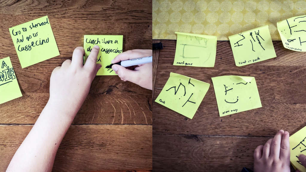 Children writing on sticky notes.