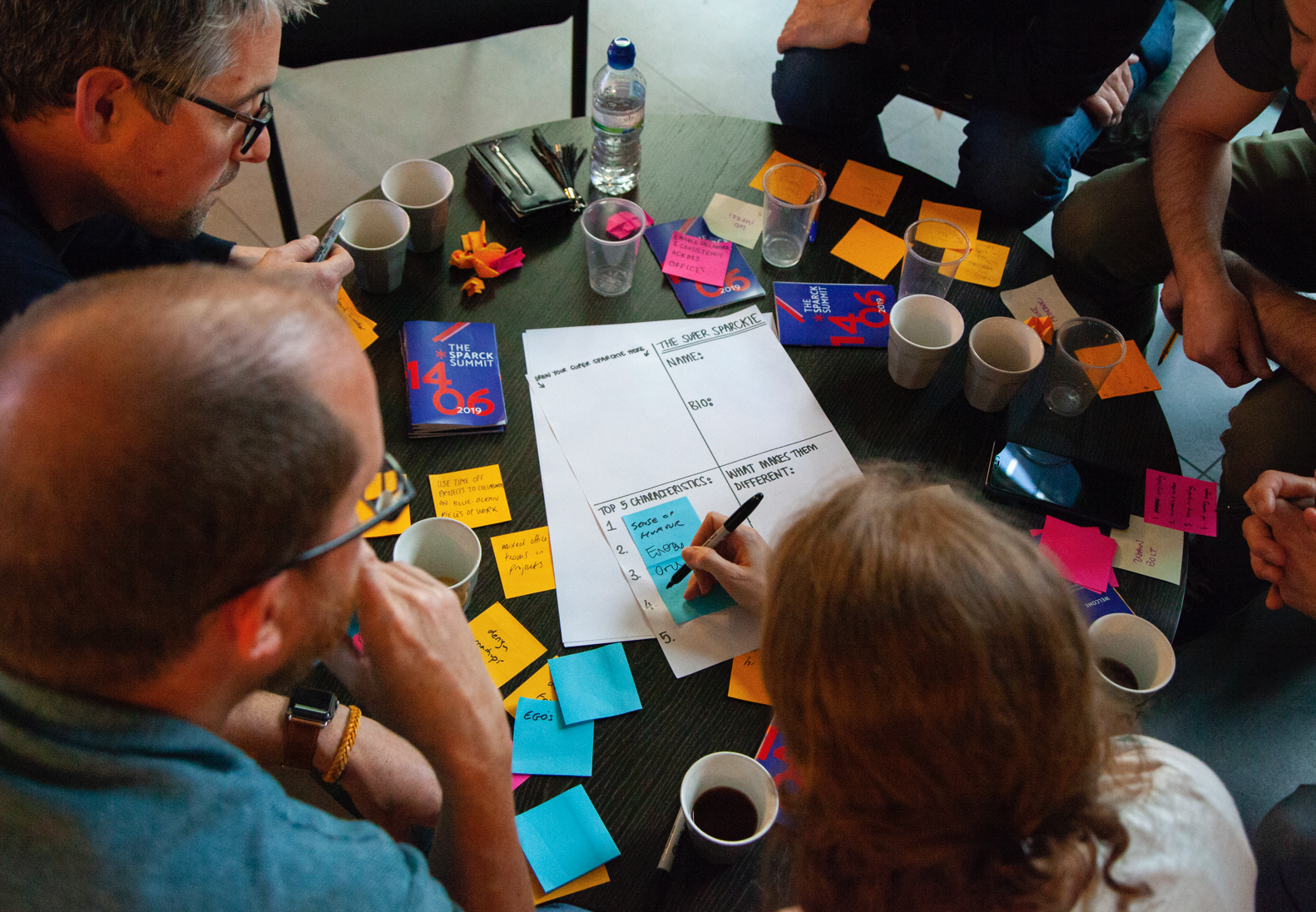 People writing on post-it notes during a workshop