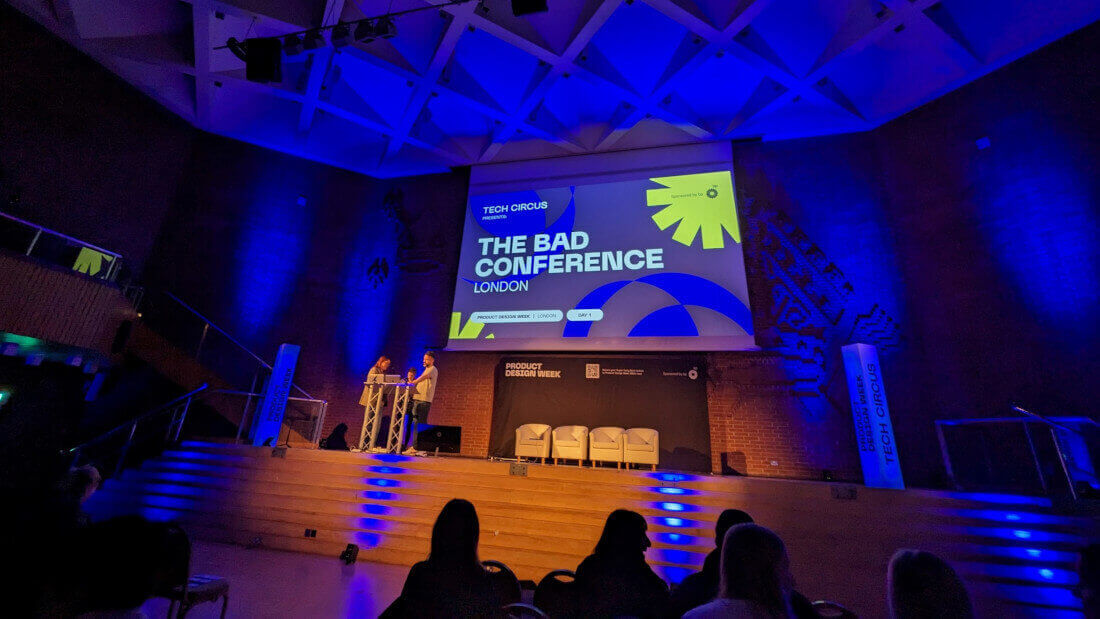The stage at the BAD conference bathed in blue light with an audience in silhouette.